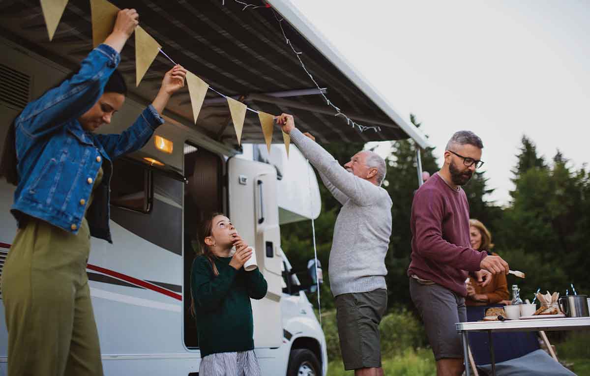 Family decorating campervan for outdoor meal
