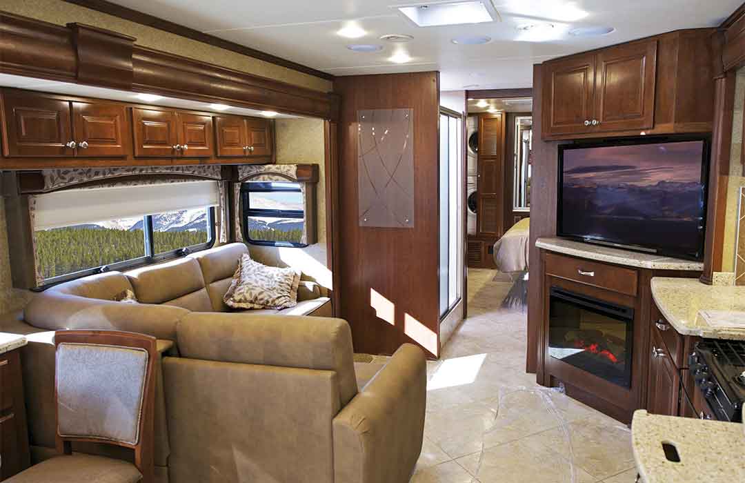 Luxurious RV interior with seating and fireplace.