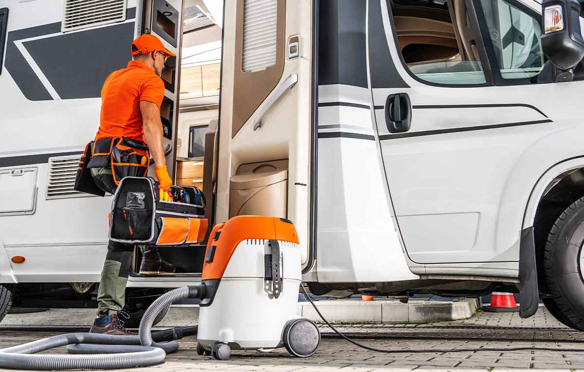 Worker cleaning RV interior with vacuum